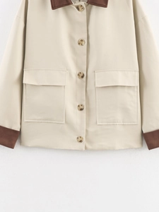 Detail of beige jacket showing brown suede collar, marble buttons and large flap pockets