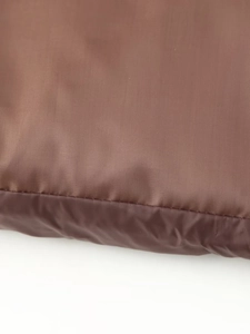Macro shot of brown synthetic fabric with silky texture and durable stitching detail