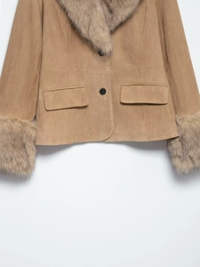 Detail of camel suede jacket featuring faux fur cuffs and symmetrical flap pockets