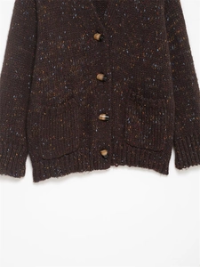 Detail of dark brown nep yarn knit cardigan with horn buttons and large patch pockets