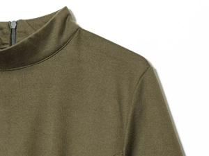 Detail of olive green high neck top featuring a smooth texture and back metal zipper