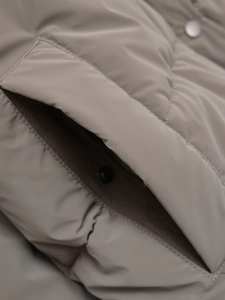 Detail view of quilted puffer jacket with metal snap button and pocket seam textures