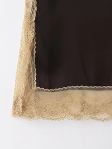Détail du tissu noir avec bordure en dentelle champagne et broderie florale