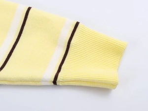Close-up of yellow and white striped knit sweater sleeve with ribbed elastic cuff