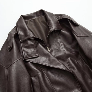 Detail of dark brown leather jacket with lapels, shoulder epaulettes and metal zippers