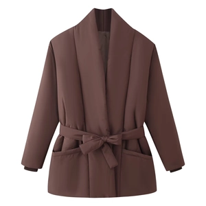 Detail of a dark brown short quilted jacket with wrap tie belt and matte texture finish