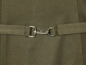 Detail of olive green knitted dress showing silver metal lobster clasp on the waist belt