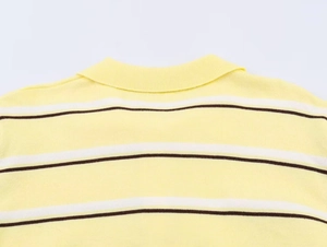 Close-up of yellow knit polo shirt showing striped collar and fine fabric texture