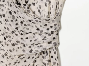 Gros plan de la robe à pois avec dentelle au décolleté et détails plissés