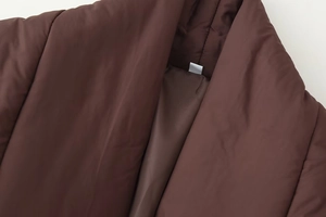 Detail view of the stand-up collar and inner lining of this warm brown quilted padded coat