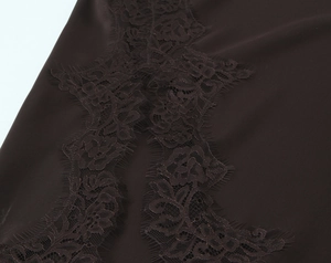 Close-up of chocolate satin fabric with intricate rose floral eyelash lace trim detail