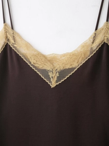 Détail de la dentelle en V et du tissu soyeux sur le haut caraco marron foncé