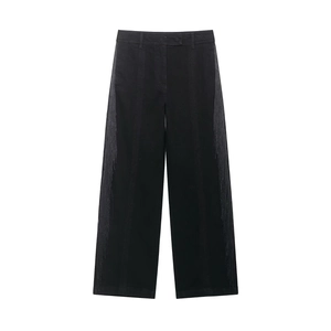Détail du pantalon noir à taille haute avec de longues franges grises sur les côtés latéraux