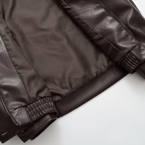 Detail view of brown PU leather jacket featuring smooth lining and metal zipper closure