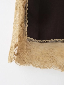 Détail du tissu marron foncé avec une bordure en dentelle florale dorée raffinée