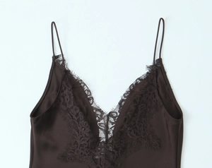 Close-up of deep brown satin dress featuring delicate eyelash lace and slim straps