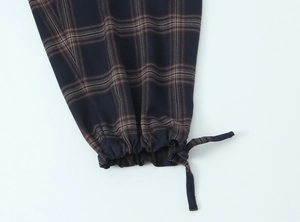 Detail view of plaid jacket elastic cuffs and adjustable drawstring on blue fabric