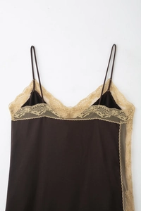Détail rapproché du caraco marron foncé avec broderies florales délicates en dentelle