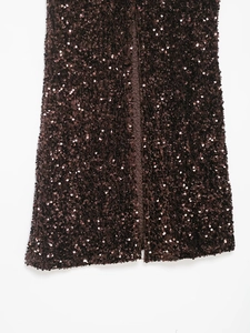 Detail view of dark brown sequined fabric with a central slit and silk lining texture