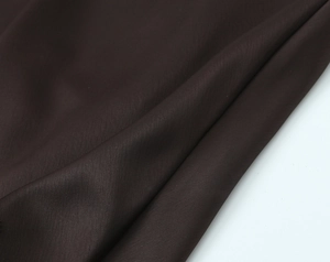 Close-up of deep brown silk satin fabric showing smooth texture and elegant drape