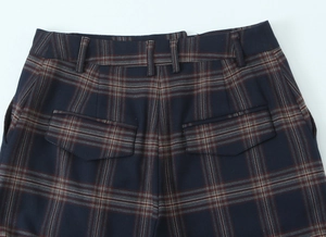Detail of navy plaid trousers showing back pockets with flaps and belt loops on fabric