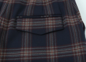 Close-up of classic navy blue plaid pattern with flap pocket detail on trousers