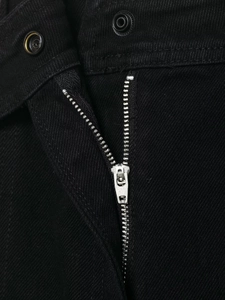 Détail de la fermeture éclair et des boutons pressions sur pantalon noir décontracté