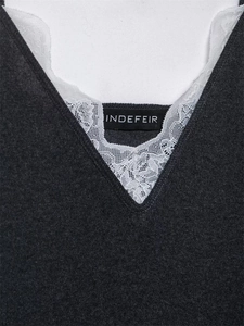 Détail du haut en maille gris foncé avec bordure en dentelle blanche et col en V
