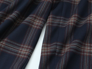 Detail of navy and burgundy plaid fabric showing stitching on the hooded jacket and pants