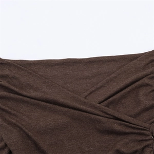 Close-up of deep brown wrap knit top showing the crossed neckline texture and fabric