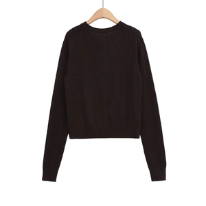 Dettaglio dello scollo a coste e della trama a maglia di questo maglione nero a maniche lunghe