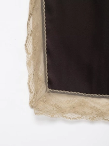 Gros plan sur tissu satiné marron avec bordure en dentelle florale beige