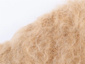 Gros plan sur la texture du tricot pelucheux marron clair aux fibres de fausse fourrure