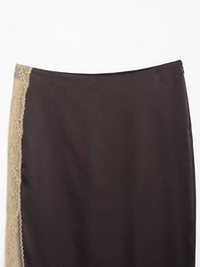 Détail d'une jupe en satin marron foncé avec bordure en dentelle beige et zip invisible