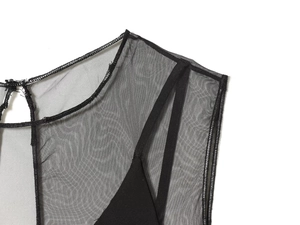 Détail de l'encolure en tulle noir avec fermeture à bouton et fines bretelles