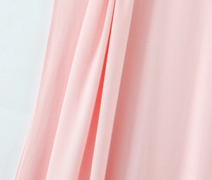 Detailed close-up showing soft pink fabric texture and natural drapes of the dress