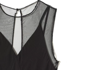 Détail de l'encolure en tulle transparent et de la fermeture à bouton sur la robe noire