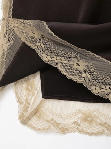 Gros plan sur un élégant satin noir avec des détails de bordure en dentelle beige