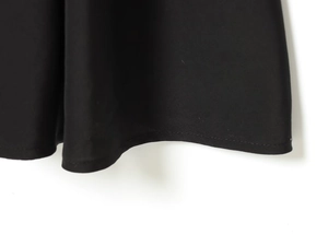 Vue détaillée de l'ourlet montrant les coutures et la texture du tissu de la robe noire