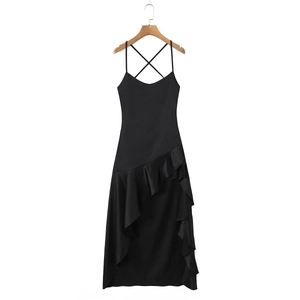 Macro detail of black satin dress featuring asymmetric ruffle hem and cross-back straps