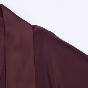 Macro shot of satin dress neckline in wine red showing smooth texture and draped collar