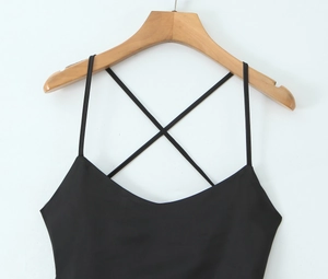 Detail of cross back straps and U-neckline on a black minimalist sleeveless dress