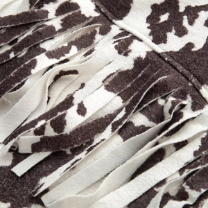 Close-up of the cow print plush fabric with stylish tassel fringe on the jacket