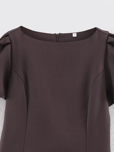 Detail von Rundhalsausschnitt und Puffärmeln an einem dunkelbraunen Kleid mit Reißverschluss