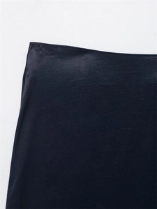 Gros plan sur le tissu satiné bleu marine de la jupe montrant la texture et la couture