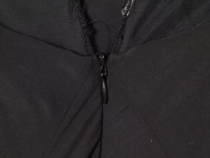 Détail d'une fermeture éclair invisible noire sur une robe en maille à texture fine