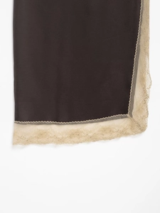 Gros plan sur le tissu soyeux marron foncé avec bordure en dentelle beige élégante