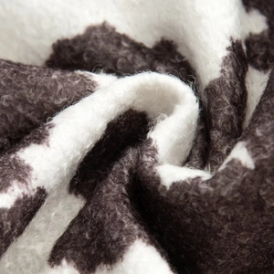 Close-up of the thick cow print sherpa fabric texture on this women's autumn jacket