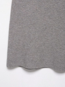 Nahaufnahme von grauem Strickstoff mit Wellensaum und detaillierter weicher Webstruktur