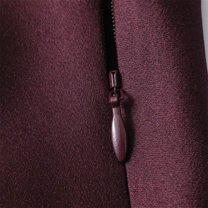 Detail of high-quality invisible zipper on wine red satin dress with fine twill texture